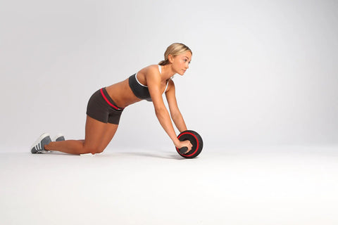 Killer Ab Rocker And Complete Core Toning Setup featuring a user demonstrating ab roller technique on a smooth floor.