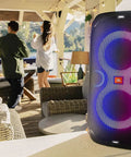 PartyBox 110 Portable Party Speaker With Built In Lights And Deep Bass 160W Power glowing in outdoor party setting