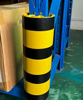Built Tough Bully Proof Heavy Duty Pallet Rack Protectors Forklift Bumper Guards For Warehouse Columns Shock Absorbing Upright Shields yellow black striped column guard with box nearby.