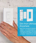 Slick Wireless Smart Dimmer Switch Plays Nice With Alexa Apple Home and Google Assistant Seamless Setup No Neutral Wire Required Smooth Hub Management For Your Entire Lighting Rig shown in hand against wall.