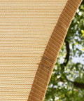Close-up of 12x16 Beige Rectangle Shade Sail With UPF50 Plus UV Blocking, Heavy Duty 200GSM HDPE Canopy material in garden setting.