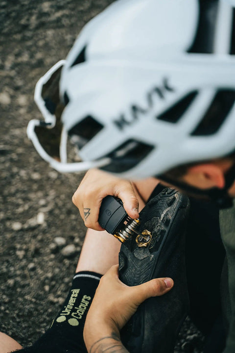 Cyclist using All-In-One Bike Multitool M19 Matte Black With Hex Wrenches for bike shoe repair
