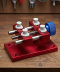 Aluminum Work Holder With Threaded Tightening Screw And Two Sliding Clamps Rock Solid Red Anodized Finish Heavy Duty Workshop Tool For Precise Part Holding And Repair on wooden bench