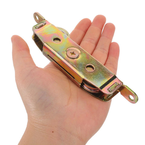 Heavy Duty Sliding Door Rollers 2 Pack Tandem Double Wheel Iron Pulley Replacement Set held in a hand, showcasing its durable design.