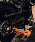 Person using Chain Cleaning Brush For Motorcycles And ATVs Universal Bicycle Chain Cleaner Tool Durable Nylon Bristles And ABS Body