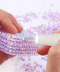Person using Badass Cordless Electric Pickup Pen With Reliable Vacuum Grip To Snag Loose Bits on a sparkly purple surface.