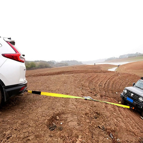 4 Pack Heavy Duty Car Trailer Tie Down Straps set in use towing car across muddy terrain, showcasing 10,000 pound break strength.