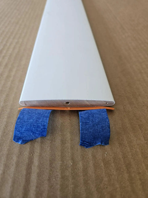 Solid Hardwood Shutter Louver Replacement Kit Five Pack, extra white painted louver with blue tape on edges to secure during installation.