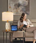 Set Of 2 Touch Control Ceramic Table Lamps For Bedroom And Living Room Modern Black And White Design With USB Ports Bedside Nightstand Lamps With Fabric Drum Shade Bulbs Included, showing one lamp on a side table beside a woman on a sofa.
