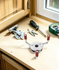 Built Tough Stainless Steel Smoke Transducer Disassembly Tool For Easy As Pie Sensor Swaps And Rock Solid Fire Safety Upkeep Featuring Corrosion Resistant Heads on a workbench with tools.