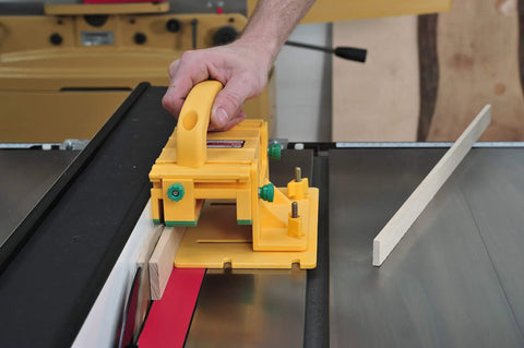 Killer Table Saw 3D Grip Pushblock with Dead Solid Kickback Stopping Guard and Sliding Blade Shield on table saw with wood.