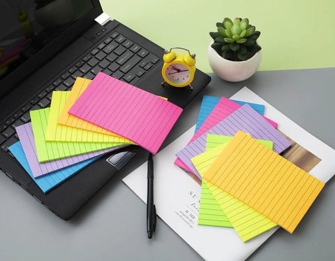 Huge 4x6 Lined Sticky Notes 12 Pack With 30 Sheets Per Pad, Ultra Sticky Notes in bright colors displayed on a desk next to a laptop.