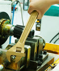 Using a non-magnetic, corrosion resistant adjustable wrench from the 16-Piece Non-Sparking Tool Set With Screwdrivers, Adjustable Wrench, Pliers, Hex Keys, Water Pump Pliers, BeCu Construction, Non-Magnetic, Corrosion Resistant, DIN Standard, BAM Certified For Pro Grade Jobs in an industrial setting.