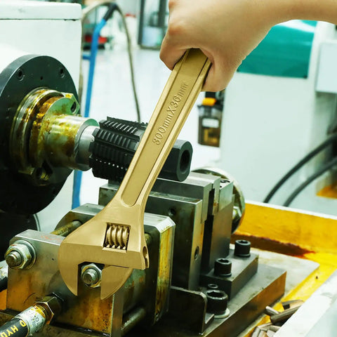 Using a non-magnetic, corrosion resistant adjustable wrench from the 16-Piece Non-Sparking Tool Set With Screwdrivers, Adjustable Wrench, Pliers, Hex Keys, Water Pump Pliers, BeCu Construction, Non-Magnetic, Corrosion Resistant, DIN Standard, BAM Certified For Pro Grade Jobs in an industrial setting.
