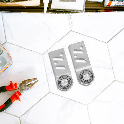 Heavy Duty Stainless Steel Sliding Door Rollers 4 Pack Featuring Precision Ball Bearings 23mm Axle on tiled surface with pliers.