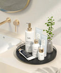 Rock Solid 12 Inch Black Oak Lazy Susan Turntable Tray with bathroom products on countertop for organized storage.