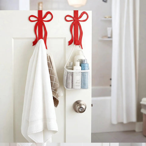 Sort Your Daily Grind Smoothly With These Heavy Duty Red Bow Over The Door Hooks Perfect For Dropping Coats Towels Hats And Bags While Keeping Main Room Coquette Vibes Strong. Red bow hooks holding towels and a basket of toiletries on a bathroom door.