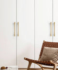 Top Shelf Gold Plated Brass Cabinet Pulls Featuring Sleek Double Hole Mounting For Drawers And Cupboards on white cabinetry.
