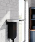 Top Shelf Stainless Steel EV Charger Rain Cover mounted to wall, shielding a black EV charger in a sunny room.