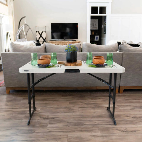 Commercial Adjustable Folding Table For Indoor And Outdoor Use 4 Foot Surface With Solid Seamless Top in a living room setting