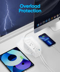 Flat Plug Power Strip With Five Foot Extension Cord Giving Six Wide Spaced AC Outlets Plus Three USB Charging Ports Including One Fast Type C, charging devices on a desk.