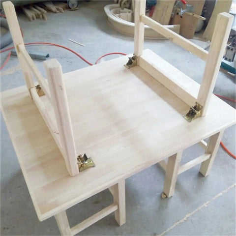 Rock Solid Four Piece Folding Brackets Slick Black Table Leg Hinges on a wooden table frame ready for assembly.