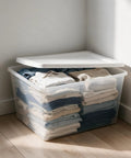 Kick Closet Clutter To The Curb With This Dang Sturdy 58 Quart Medium Clear Plastic Storage Bin Featuring A Secure Snap On Lid For Effortless Vertical Stacking And Hassle Free Toy Organization, filled with folded clothes.