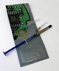 0.7ml Silver Conductive Paste Pen For PCB Repair next to two needle sizes on circuit board