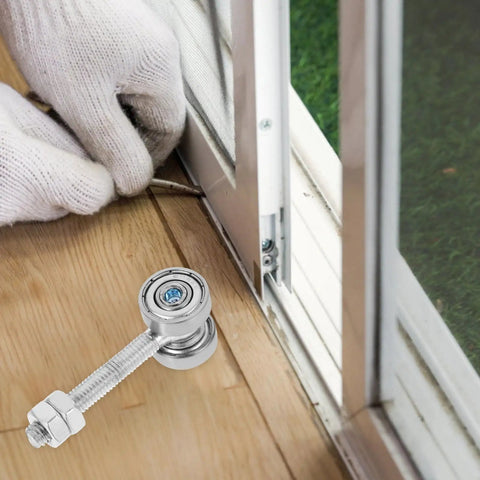 Tough As Nails Dual Wheel Sliding Door Roller Pulley with Double Bearings being installed with glove on a wooden floor.