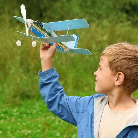 Boy holding a toy biplane outdoors, showing 12 Pack Metal Clevis Quick Links 3mm M3 Thread Steel Self Locking Clips For RC Airplane Car And Helicopter Models 30mm Length Replacement Hardware For DIY RC Projects And Linkage Assemblies.