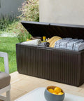 Springwood 80 Gallon Resin Outdoor Storage Box for Patio Cushions, Pool Toys, Garden Tools with open lid, showing storage with natural surroundings