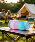 Powerful Portable Wireless Bluetooth Speaker With Stereo Sound LED Lights And Long 36 Hour Battery Life IPX4 Waterproof BT53 TWS Pairing Built In Mic Ideal For Outdoors Home Parties And Travel Powder Blue Gift on a table outdoors with camping scene in background.