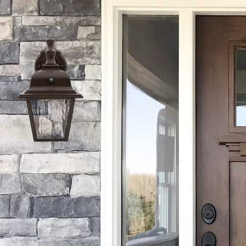 LED Porch Lantern Outdoor Wall Light In Aged Bronze With Clear Water Glass, Dusk to Dawn Sensor on stone exterior wall