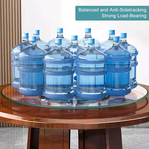 Large Round Lazy Susan With Solid 360 Smooth Spin Heavy Duty Tempered Glass Turntable Tray displaying water jugs on a wooden table.