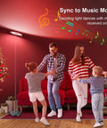 Family dancing next to Two-Sided Smart Floor Lamp With RGBCW Color, 2000 Lumens, Alexa And Google Home Ready, 66 Inch Tall, Black.