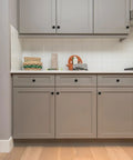 Dang Slick Matte Black Finish Round Cabinet Knobs Zinc Hardware Big Time Kitchen Refresh gold on grey kitchen cabinets.