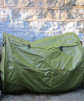Roll Mix Compost Bin Tumbler For Home Garden Green 41 Gallon Capacity 26 Inches Wide next to stone wall