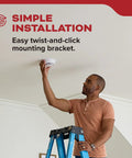 Man installing Two Pack Smoke Detector AA Battery Powered Model 20SDR using easy twist-and-click bracket on ceiling.