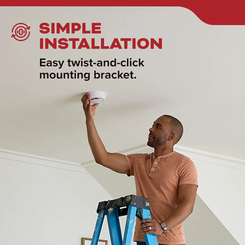 Man installing Two Pack Smoke Detector AA Battery Powered Model 20SDR using easy twist-and-click bracket on ceiling.