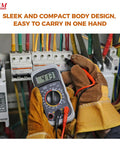 Person holding Versatile Digital Multimeter 600 Volt AC DC Voltage Meter With Backlit LCD Display in front of circuit board.