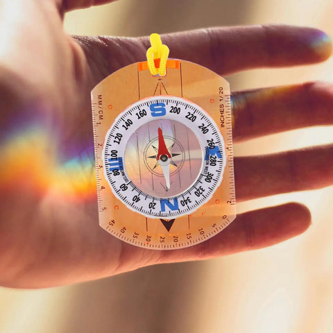 Hand holding Luminous Orienteering Compass With Ruler And Direction Pointer For Hiking And Camping Lightweight Outdoor Navigation Tool