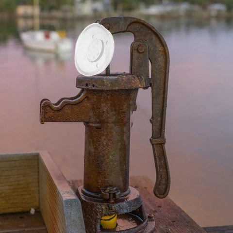 Four Piece Pitcher Pump Gasket Set For Hand Water Pumps White PVC Sealing Gaskets shown atop rusted water pump