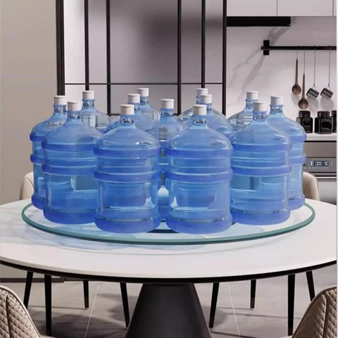 Smooth Operator Tempered Glass Lazy Susan Turntable Serving Tray Hella Sturdy Silent Bearing Rotation For Dining Table Kitchen Centerpiece 70 Cm Dinner Upgrade with water bottles on a clear glass tray.