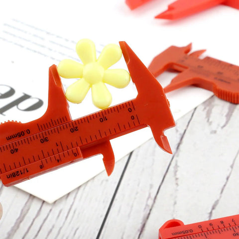 Depth Vernier Caliper Micrometer Gauge Measuring Tool measuring a yellow flower, red plastic design, suitable for various lengths.