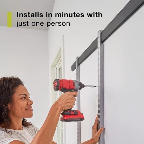 Person installing a Customizable Wall Shelving System With Adjustable Hooks And Heavy Duty Rails for garage storage.