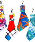 Set of four double-sided microfiber glasses cleaning cloths with metal carabiner clips, featuring abstract art patterns.