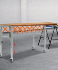 Expandable Adjustable Conveyor Roller Table 18 To 51 Inch Length, in workshop setting, with metal frame and wooden top.