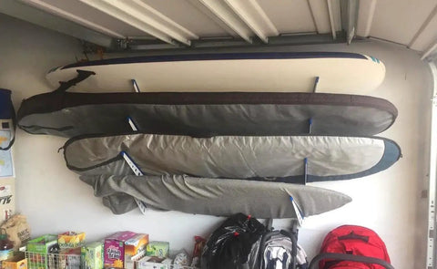 Dude Approved Surfboard Wall Mount Rack With Padded Arms Holds Four Shred Ready Boards Adjustable Height Wall Storage Organizer keeping boards secure in garage.
