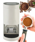 Automatic Electric Coffee Tamper For Espresso With Adjustable 5 To 30 Kilogram Pressure And Universal Portafilter Base on display with ground coffee.