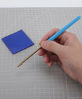 Flame Test Kit With Blue Cobalt Glass Filter And Metal Wire For Metal Ion Flame Tests, shown with wire loop on grid surface